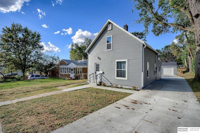 view of front of house with a garage, a front lawn, and an outdoor structure