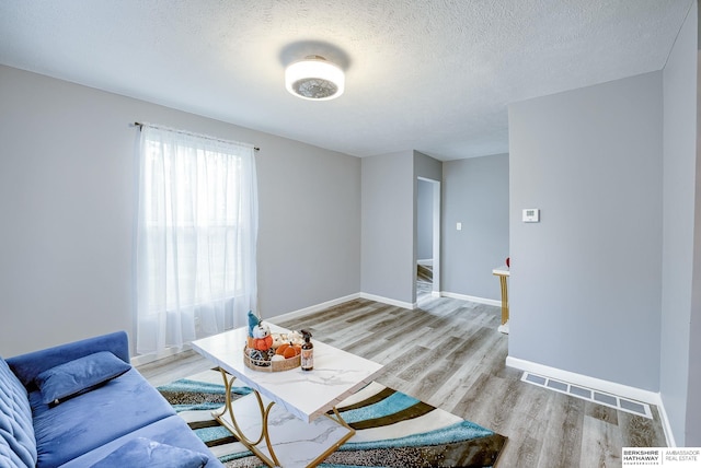 sitting room with a textured ceiling and light hardwood / wood-style flooring