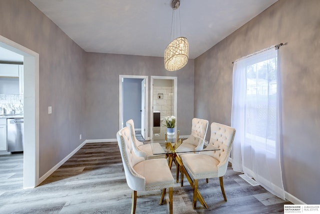 dining space featuring wood-type flooring and a chandelier