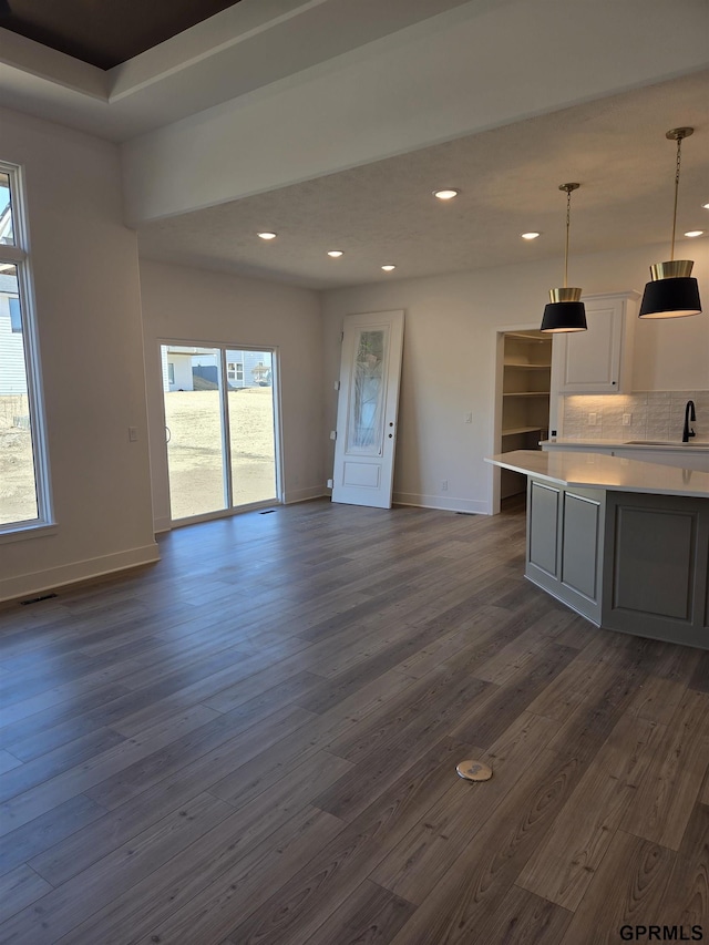 kitchen with tasteful backsplash, dark wood-type flooring, open floor plan, light countertops, and recessed lighting