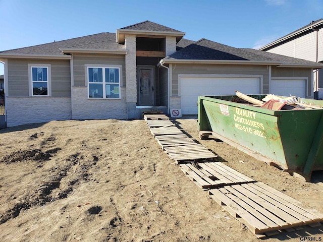 view of front facade featuring an attached garage and roof with shingles