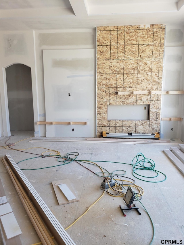 unfurnished living room featuring arched walkways