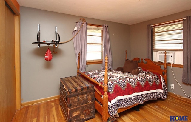 bedroom with cooling unit and light hardwood / wood-style flooring