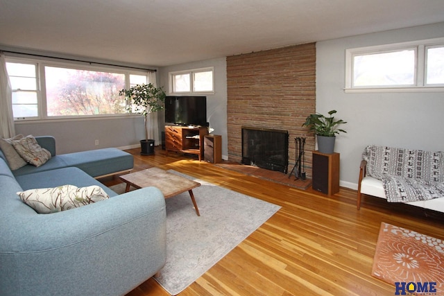 living room featuring hardwood / wood-style flooring and a stone fireplace