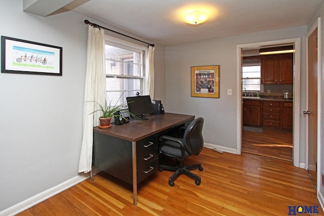 home office with light hardwood / wood-style floors