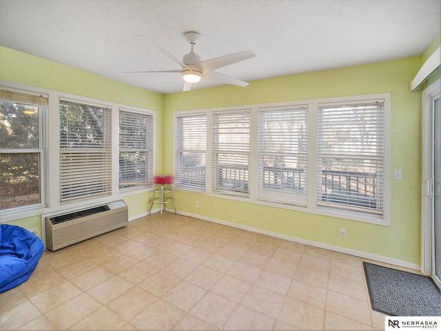 unfurnished sunroom featuring plenty of natural light, a wall mounted air conditioner, and ceiling fan