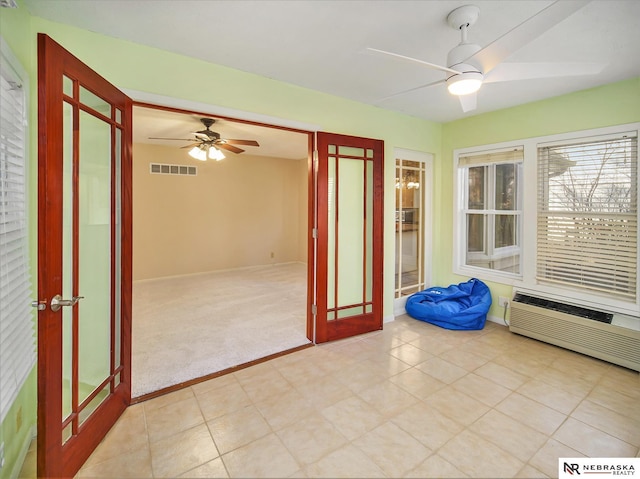 unfurnished sunroom featuring french doors, ceiling fan, and an AC wall unit