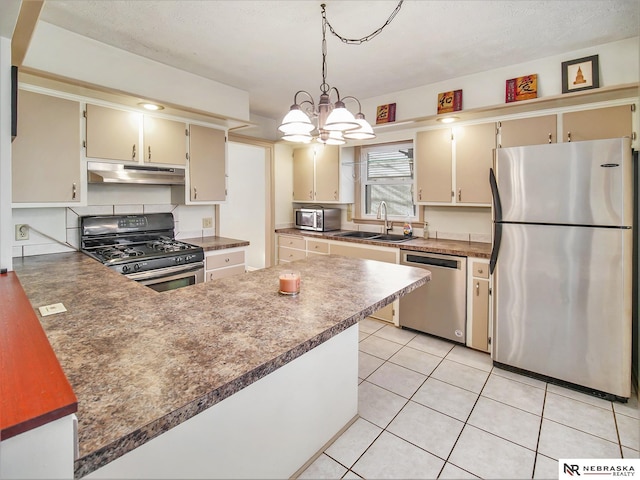 kitchen featuring sink, light tile patterned floors, a notable chandelier, stainless steel appliances, and cream cabinets