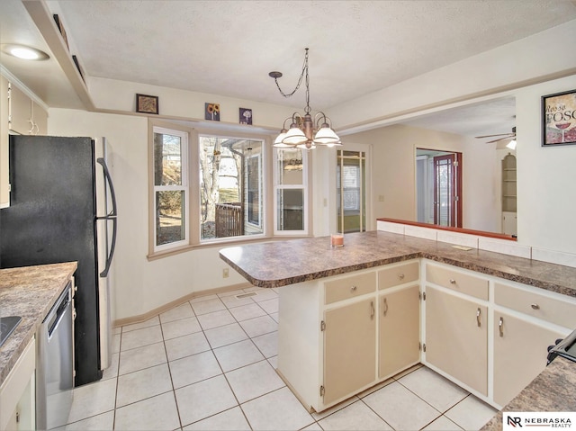 kitchen featuring stainless steel appliances, light tile patterned flooring, decorative light fixtures, and kitchen peninsula