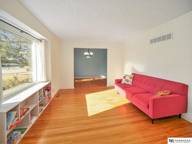 living room with hardwood / wood-style flooring and a notable chandelier