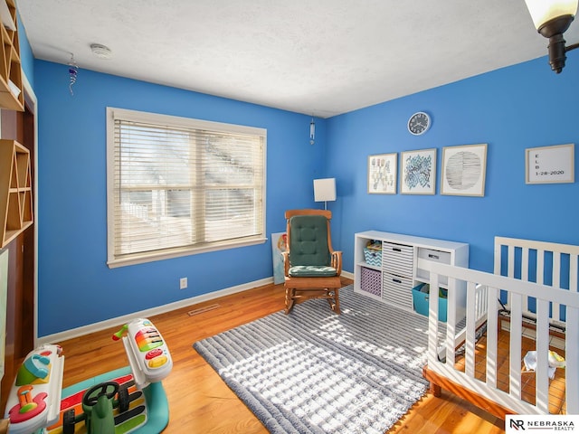 bedroom featuring hardwood / wood-style floors and a textured ceiling