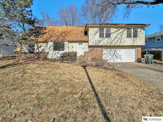 tri-level home featuring a garage and a front yard