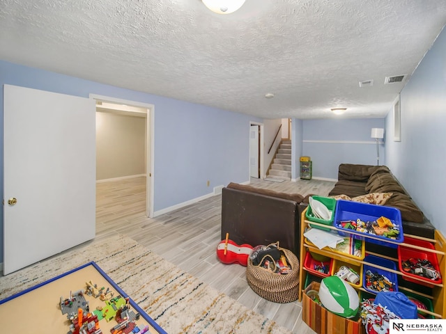 recreation room with a textured ceiling