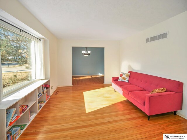 living room with an inviting chandelier and hardwood / wood-style flooring