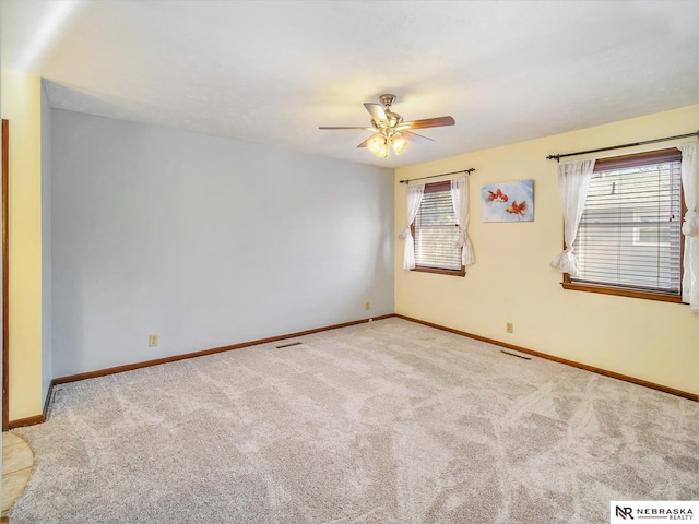 carpeted spare room featuring ceiling fan