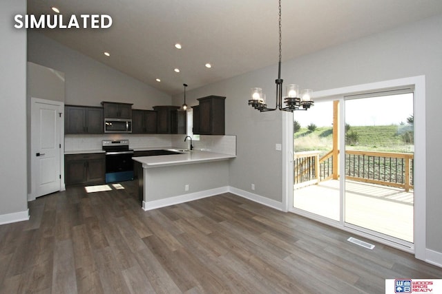 kitchen featuring kitchen peninsula, pendant lighting, stainless steel appliances, and sink