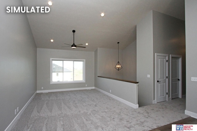 empty room with carpet flooring, high vaulted ceiling, and ceiling fan