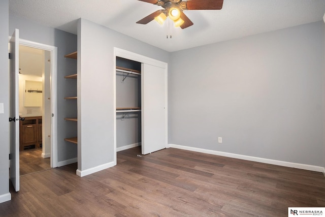 unfurnished bedroom with a textured ceiling, ceiling fan, and dark hardwood / wood-style floors