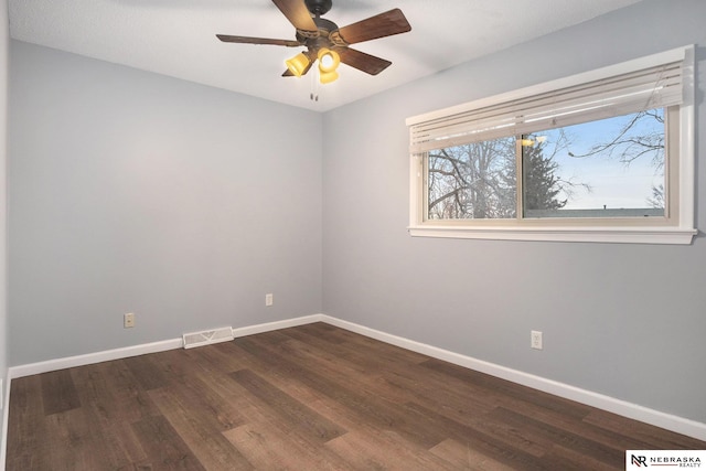 spare room featuring ceiling fan and dark wood-type flooring