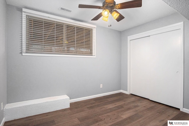 unfurnished bedroom featuring ceiling fan, dark hardwood / wood-style flooring, and a closet