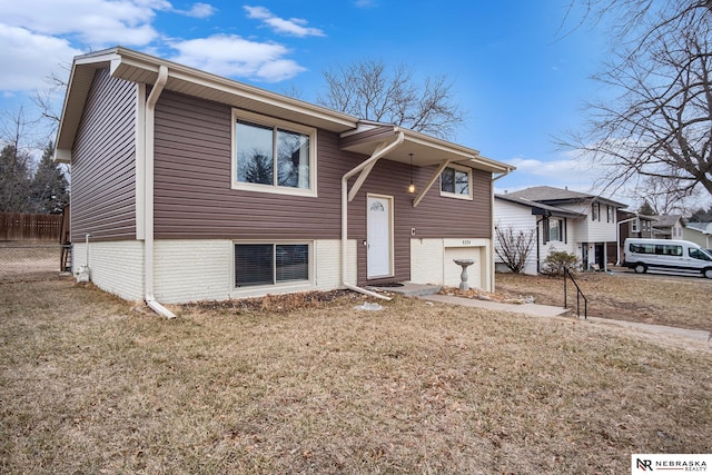 split foyer home featuring a garage and a front lawn