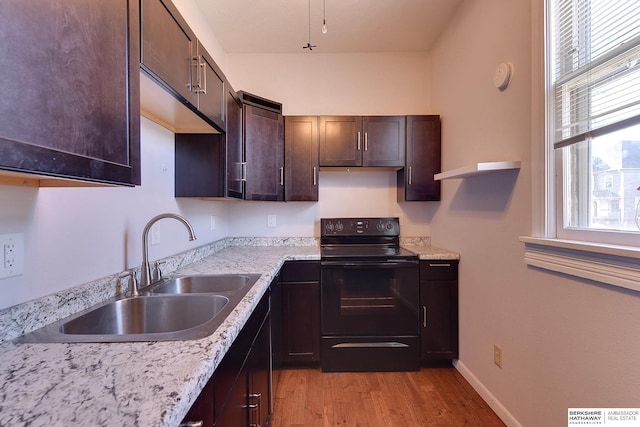 kitchen with sink, plenty of natural light, electric range, and light hardwood / wood-style flooring