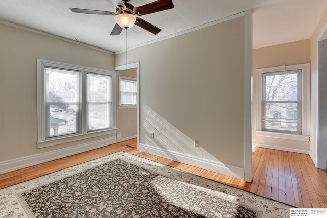 unfurnished room featuring crown molding, light wood-type flooring, a healthy amount of sunlight, and ceiling fan