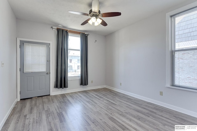 unfurnished room featuring plenty of natural light, a textured ceiling, ceiling fan, and light hardwood / wood-style floors