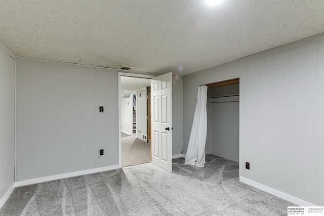 unfurnished bedroom featuring carpet flooring, a closet, and a textured ceiling