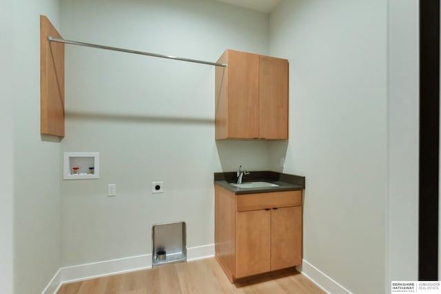 clothes washing area with hookup for an electric dryer, light hardwood / wood-style floors, sink, and hookup for a washing machine