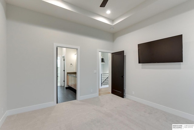 unfurnished bedroom with ensuite bath, ceiling fan, and carpet floors