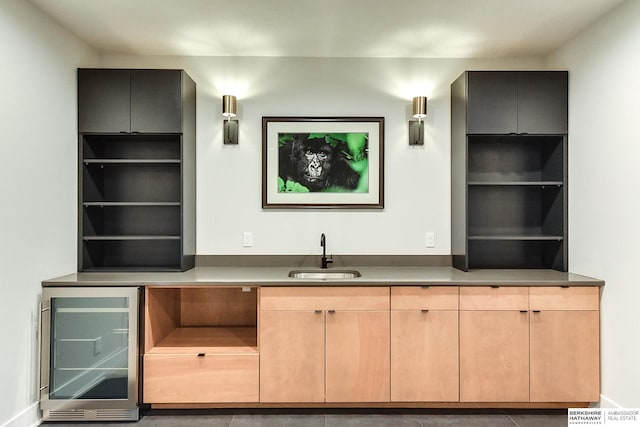 bar featuring wine cooler, sink, light tile patterned floors, and light brown cabinetry