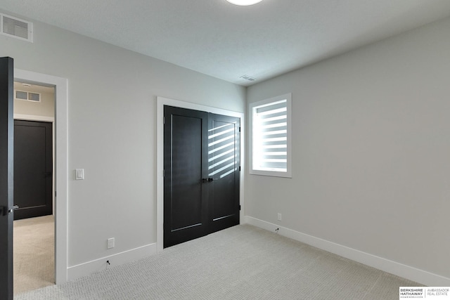 unfurnished bedroom with light colored carpet