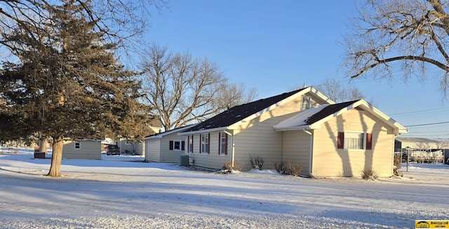 snow covered property with cooling unit