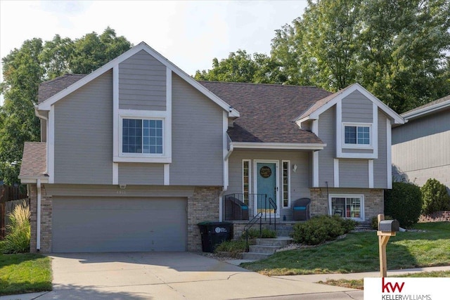 bi-level home with a garage and a front lawn