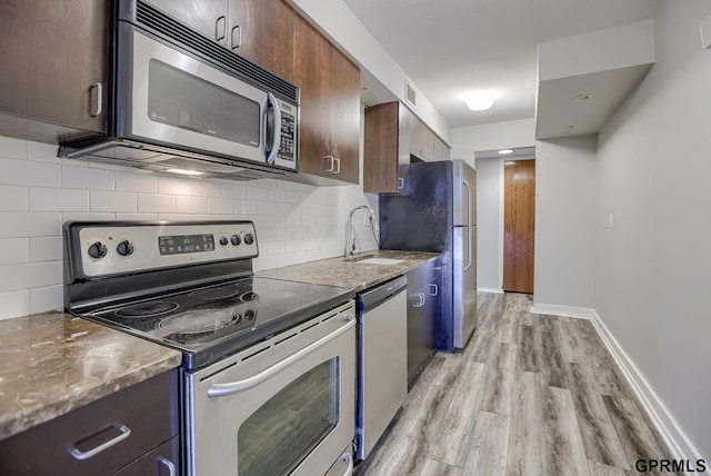 kitchen featuring dark brown cabinetry, stainless steel appliances, tasteful backsplash, and sink