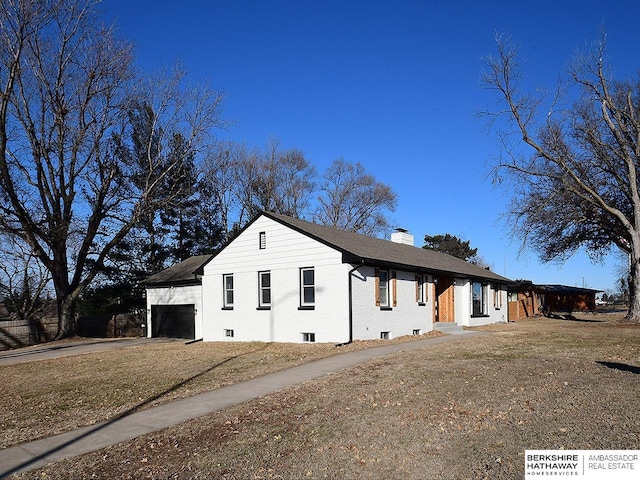 view of side of property with a garage and a lawn