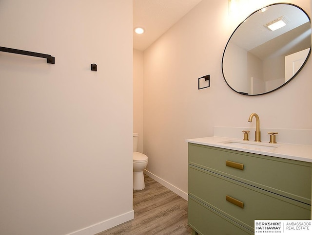 bathroom with hardwood / wood-style floors, vanity, and toilet