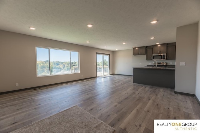 unfurnished living room with light hardwood / wood-style flooring and sink