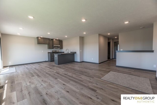 unfurnished living room with light hardwood / wood-style flooring and sink