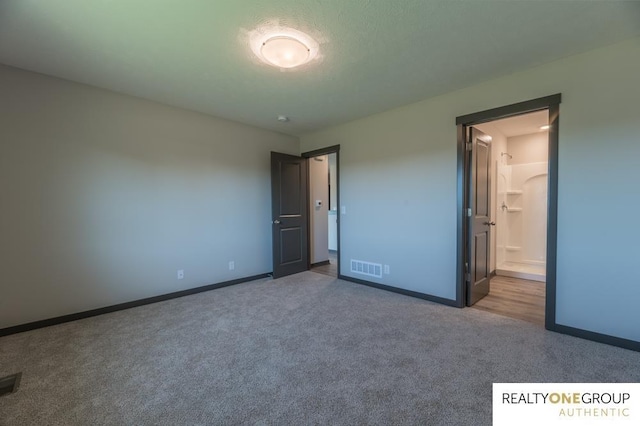 unfurnished bedroom featuring carpet and ensuite bathroom