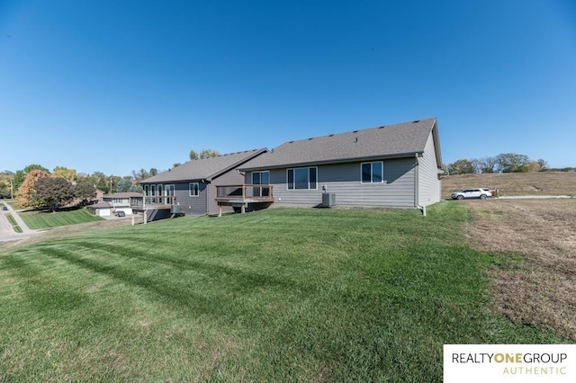 rear view of house with a yard and central AC unit