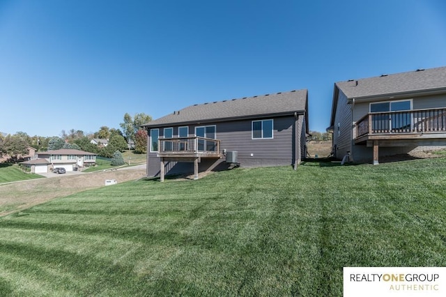 back of house featuring a lawn, a wooden deck, and central AC unit