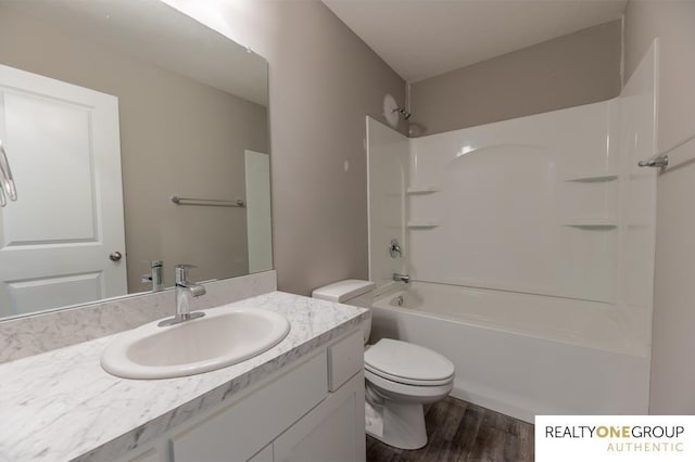 full bathroom featuring shower / washtub combination, vanity, hardwood / wood-style floors, and toilet