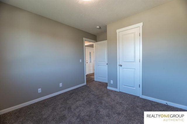 unfurnished bedroom featuring dark colored carpet