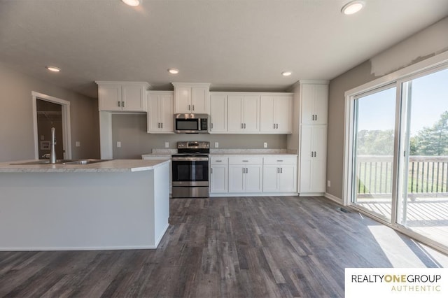 kitchen featuring dark hardwood / wood-style flooring, white cabinetry, sink, and stainless steel appliances