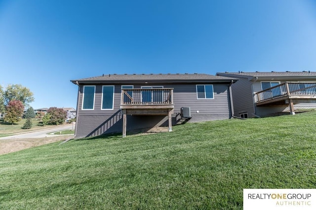 rear view of property with a yard, cooling unit, and a deck