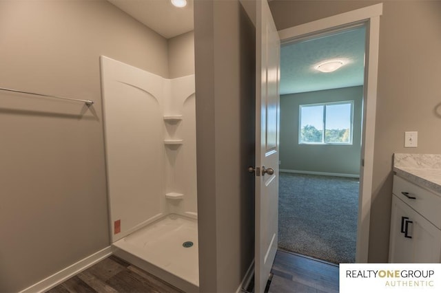 bathroom with a shower, wood-type flooring, and vanity