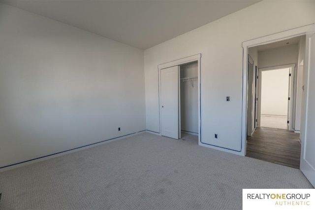 unfurnished bedroom with light colored carpet and a closet