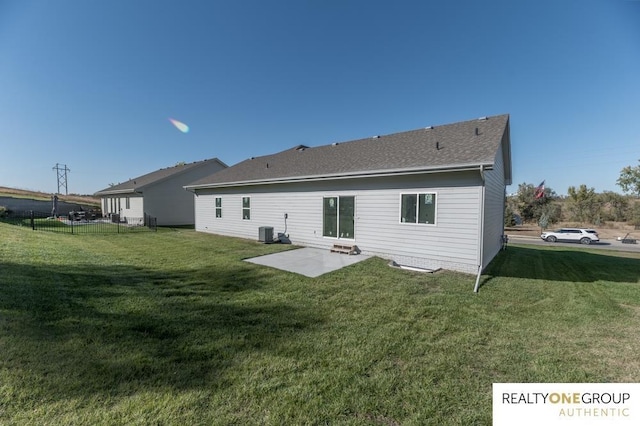 rear view of property featuring a lawn, central air condition unit, and a patio